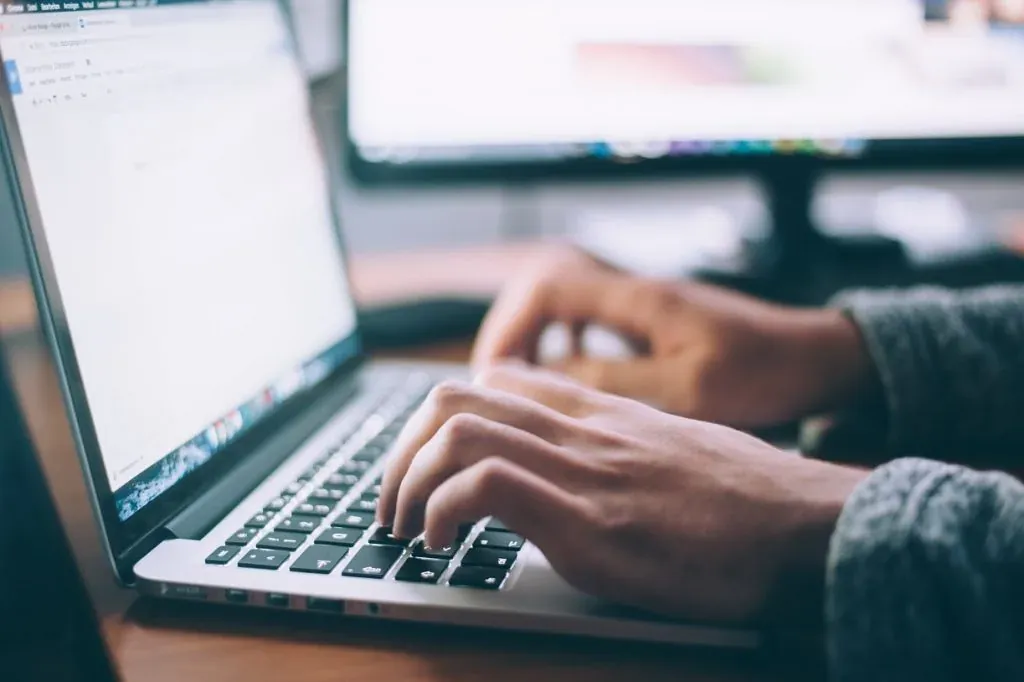 Person schreibt Content für einen Online-Shop am Laptop